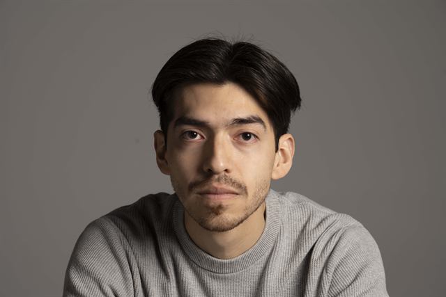 Juan Diego Hernández, jersey gris sobre fondo gris