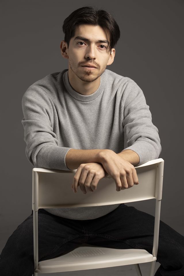 Juan Diego Hernández sentado en una silla con jersey gris