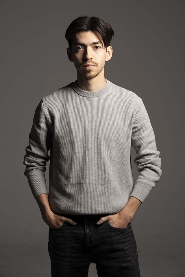 Juan Diego Hernández de cuerpo entero con jersey gris