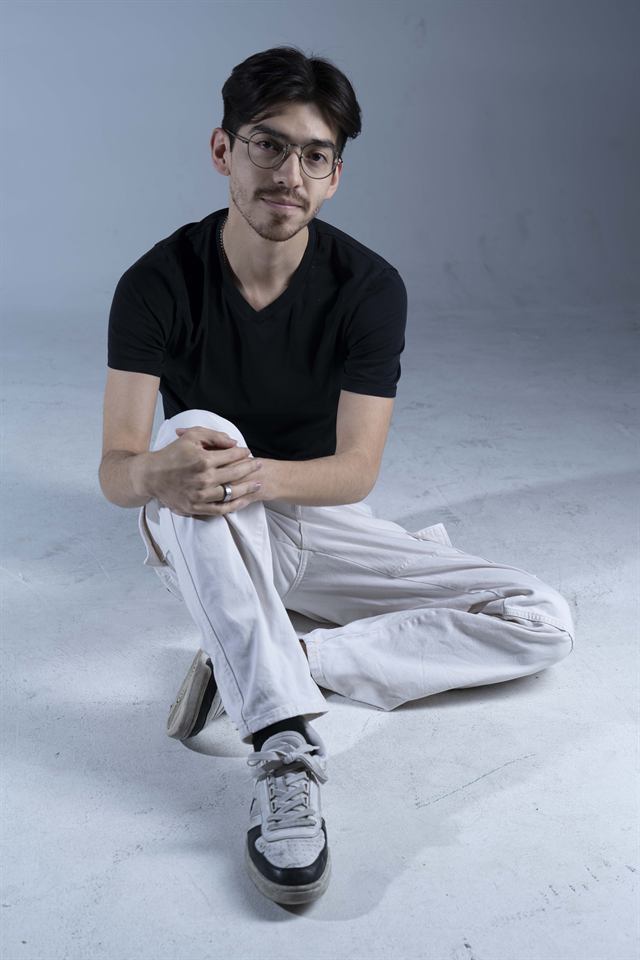 Juan Diego Hernández con camiseta negra y gafas, sentado en el suelo